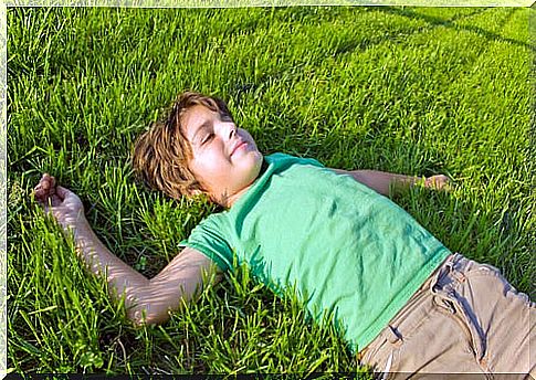 boy lying on the grass representing how to raise independent children