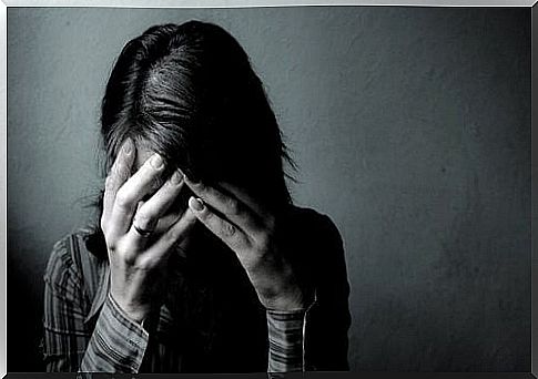 Woman with depression covering her face with her hands