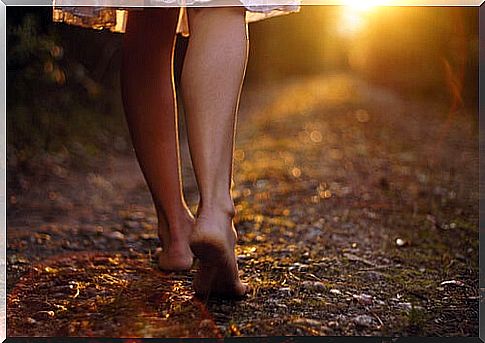 Barefoot woman walking down a path