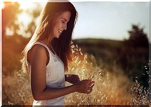 Happy woman in the field thinking that thinking that I am grateful for everything that I have overcome