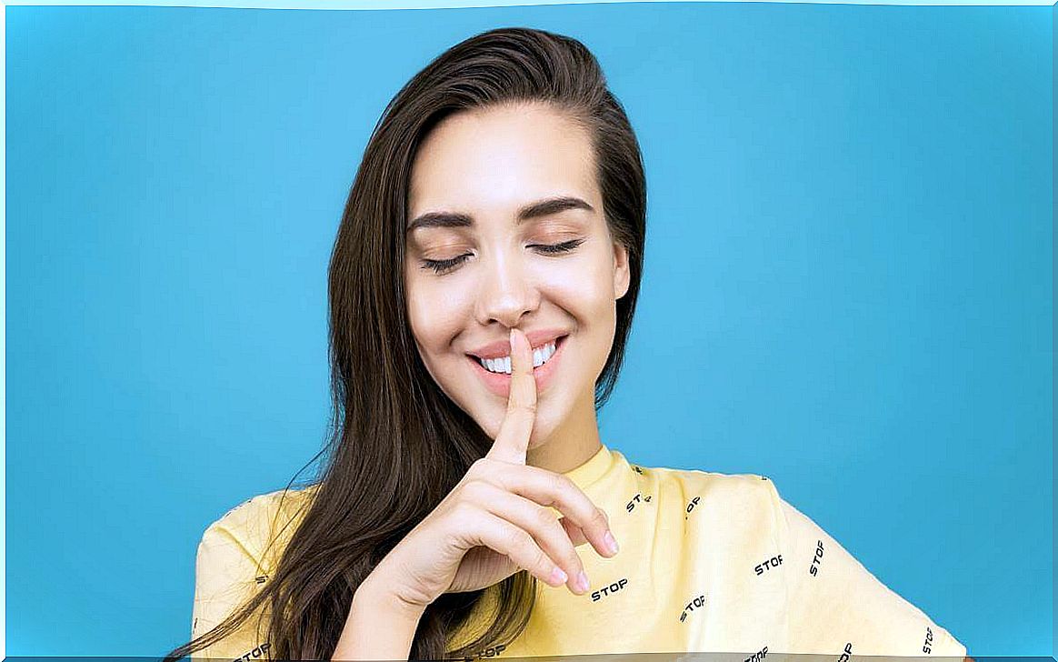 Girl making the silence gesture to symbolize the People who speak little