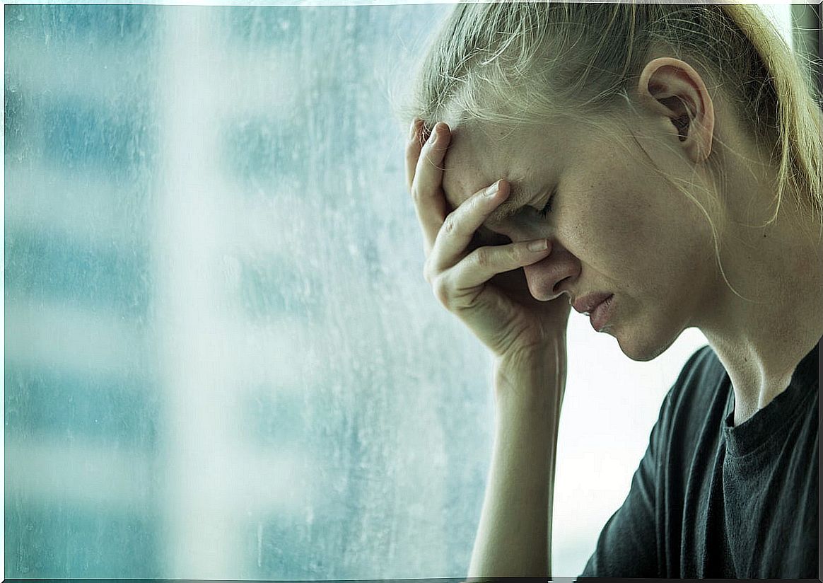 Woman with hand on forehead for anxiety