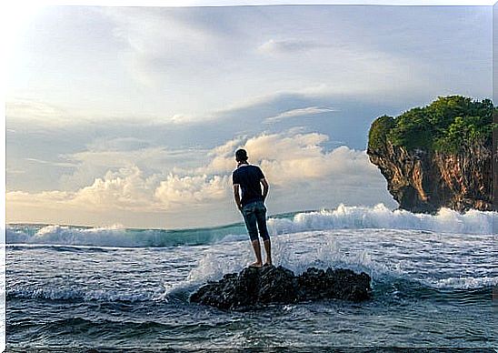 boy on a rock in the sea representing calm people 