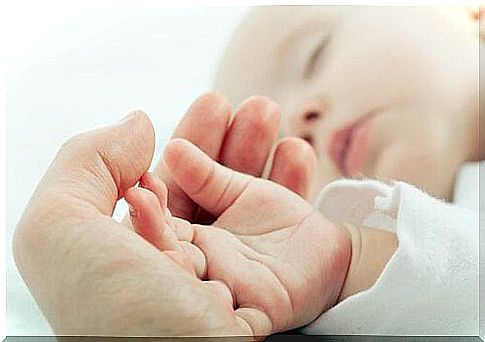 Mothers holding their baby's hand with attachment