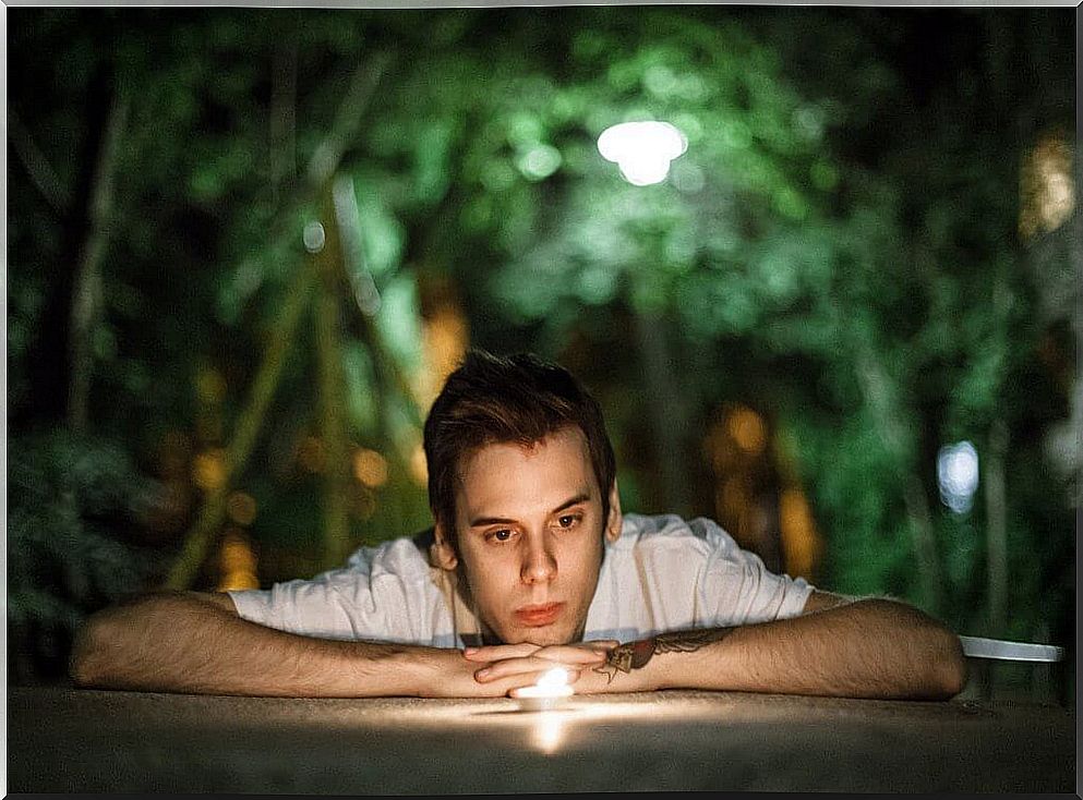 Boy looking at a burning candle