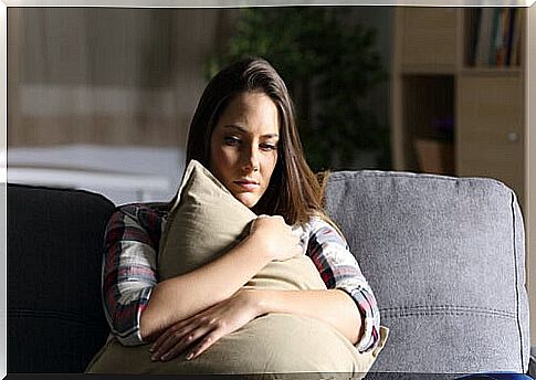 Woman in fear hugging a cushion