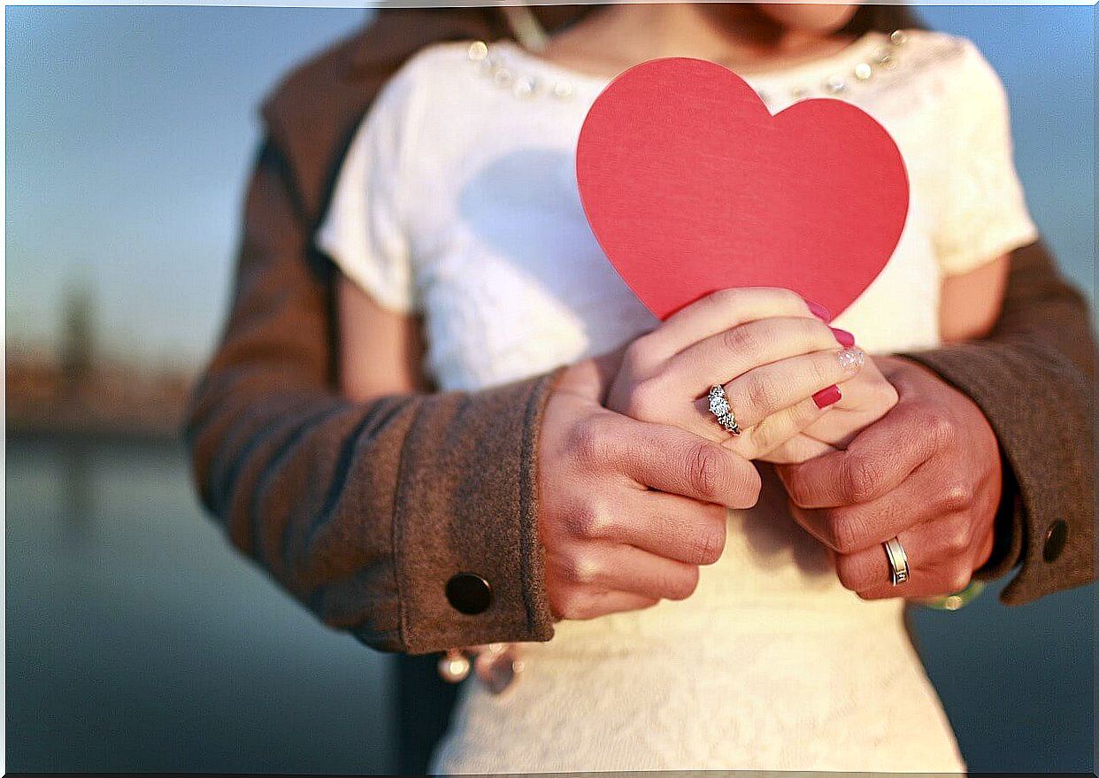 Couple embracing holding a heart